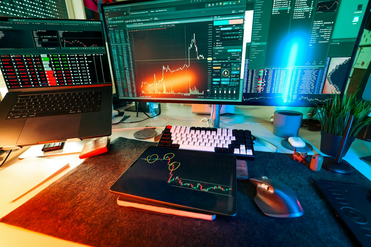 Mehrere Computermonitore zeigen Finanzdiagramme auf einem Schreibtisch.